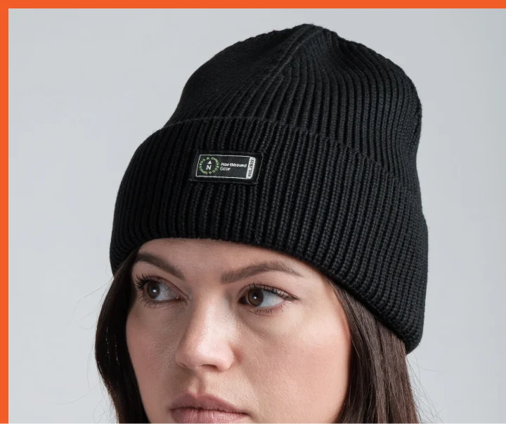 Beanie design, carrying the refreshed identity on a woven label.